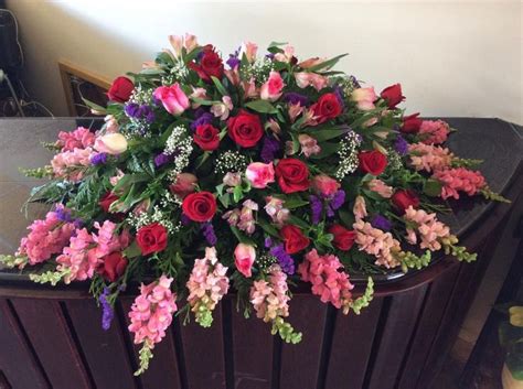 A full Casket spray for a woman in all pink, purple and burgundy coloured flowers. The snap ...