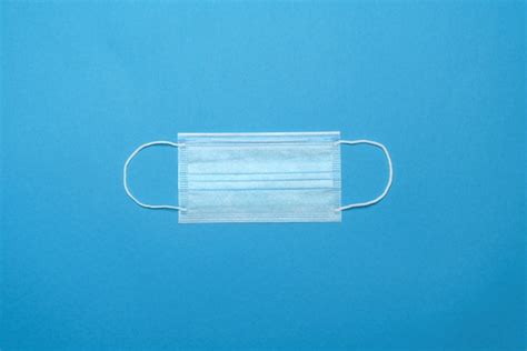 Premium Photo | Disposable blue medical face mask on blue background.