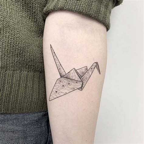 Origami crane tattoo on the inner forearm.