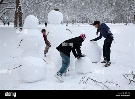 People making snowman family Stock Photo - Alamy