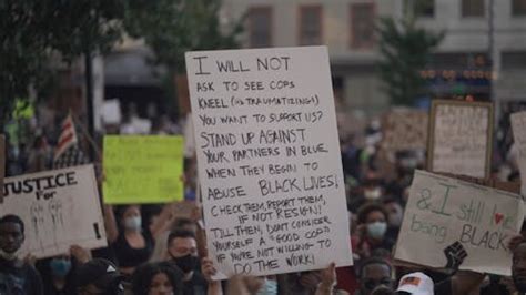 Woman Holding a Protest Sign on the Street · Free Stock Video