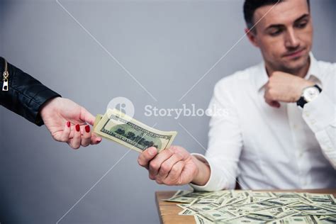 Unhappy man giving money to woman Royalty-Free Stock Image - Storyblocks