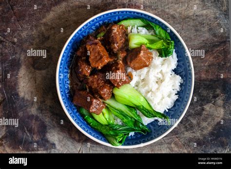 Spicy Chinese style braised beef with rice and pak choi Stock Photo - Alamy