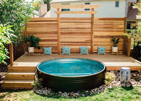 an above ground pool surrounded by wooden decking and seating area in the back yard