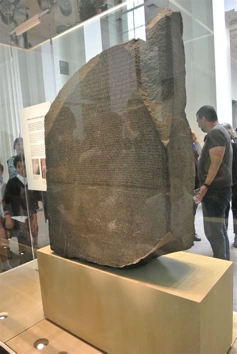 a large rock is on display in a glass case with people standing around it and looking at it