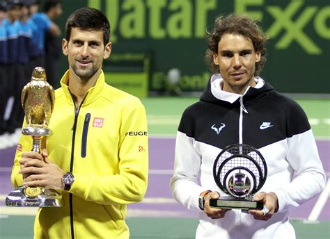 Djokovic of Serbia holds the trophy as he stands next to second place Nadal of Spain after ...