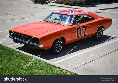 Download An Orange Dodge Charger Parked In A Parking Lot Wallpaper ...