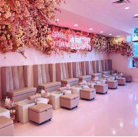 a room filled with lots of tables covered in white and pink flowers on the wall