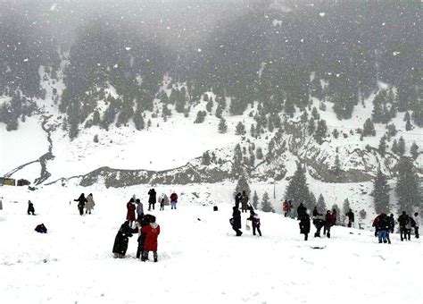 Tourists are seen enjoying and playing amid fresh snowfall at Sonamarg