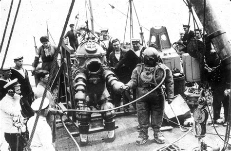 Two divers, one wearing the "Tritonia" ADS and the other standard diving dress, preparing to ...