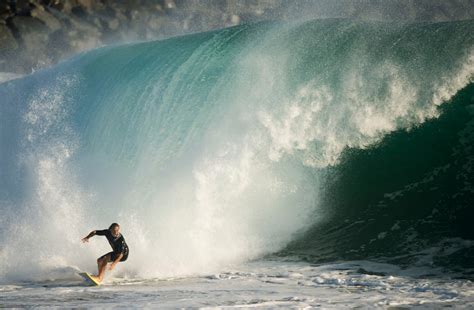 Summer-like waves in October? These photos show surfers enjoying big waves, unseasonably warm ...