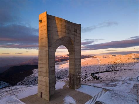 Bella vista aerea delle montagne innevate e del monumento arco della libertà sulla cresta ...