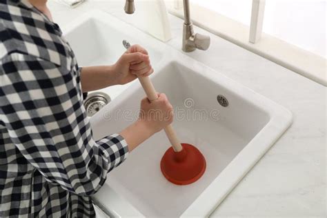 Woman Using Plunger To Unclog Sink Drain in Kitchen, Closeup Stock ...