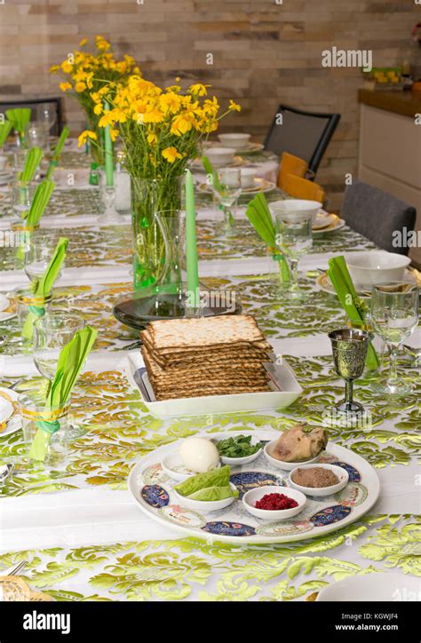 Modern festive Passover Seder table with green and gold decorations in ...