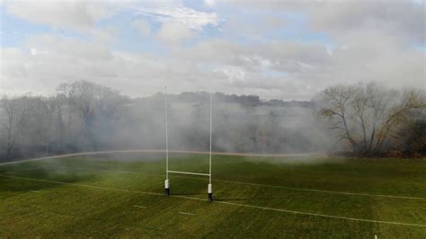 fog is coming off the grass on a rugby field