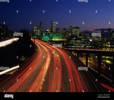 Seattle skyline illuminated at dusk with city lights and car traffic ...