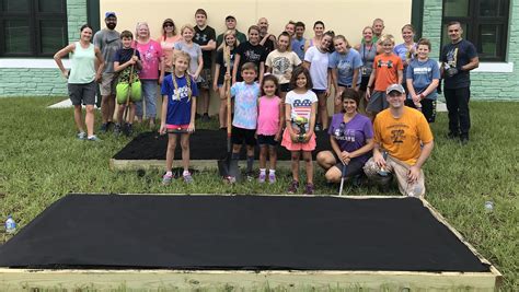 Volunteers build raised garden beds at Palm Valley Academy