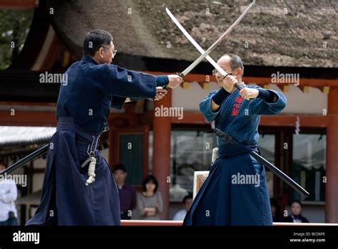 Two men engaged in a sword fight using real samurai swords during a martial arts demonstration ...