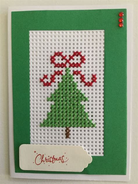 a cross stitch christmas card with a tree
