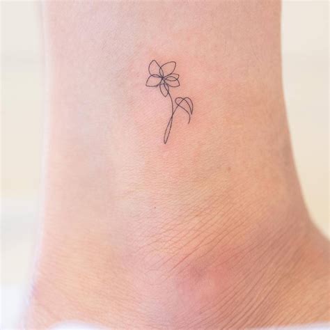 One line flower tattoo located on the ankle.