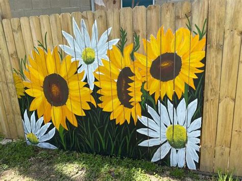 a painting of sunflowers painted on the side of a fence