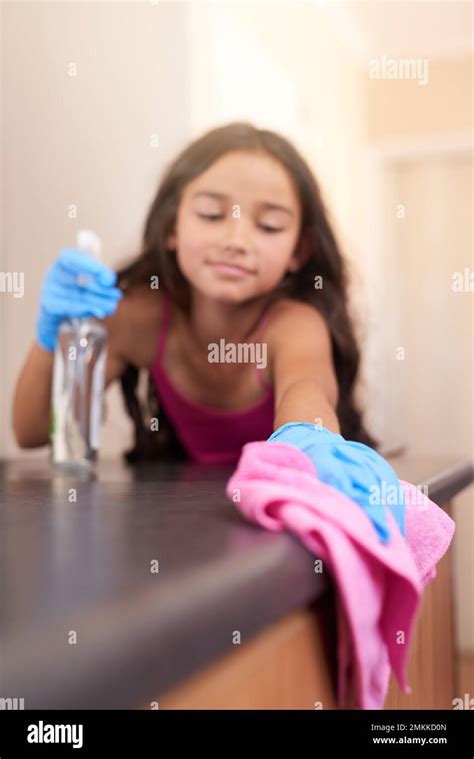 Cleaning up after herself. a young girl wiping a kitchen table with a cloth at home Stock Photo ...