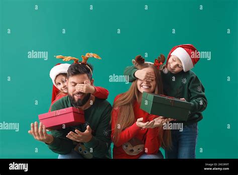 Little children surprising their parents with Christmas gifts on green background Stock Photo ...