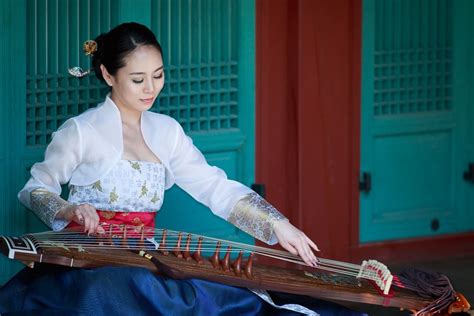 A Korean woman wearing a traditional Hanbok, playing the Gayageum. | Modern hanbok, Hanbok ...