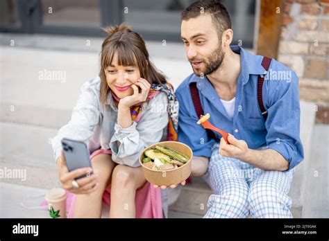 Colleagues eat healthy take away food and talk on phone outdoors Stock Photo - Alamy