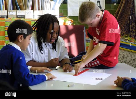 Primary students working together on a math problem using measurements ...