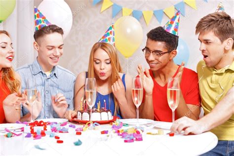 Young people celebrating a birthday sitting at the table — Stock Photo © Dmyrto_Z #72940955