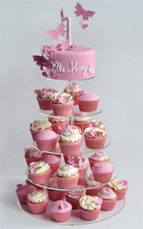 cupcakes are arranged in the shape of a tower with pink frosting and butterflies on top