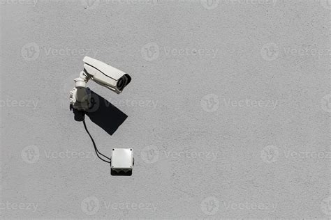 small white surveillance camera on flat gray matte plaster wall 12633287 Stock Photo at Vecteezy