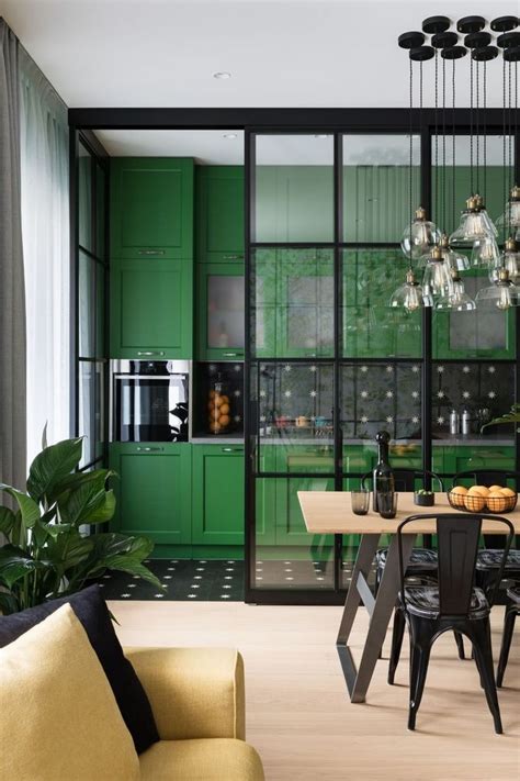 a kitchen with green cabinets and black chairs