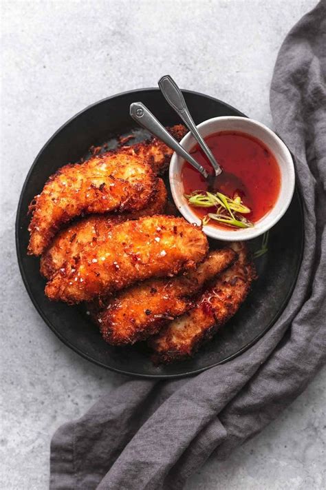 overhead view of chicken tenders on black plate with gray napkin and ...