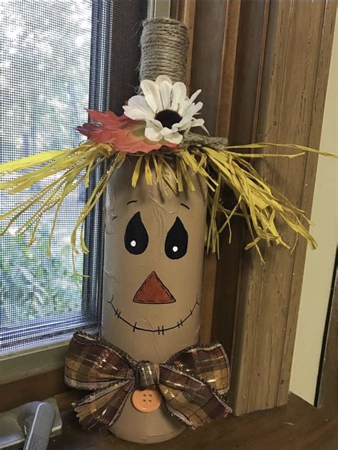 a scarecrow decoration made out of toilet paper rolls with flowers on ...