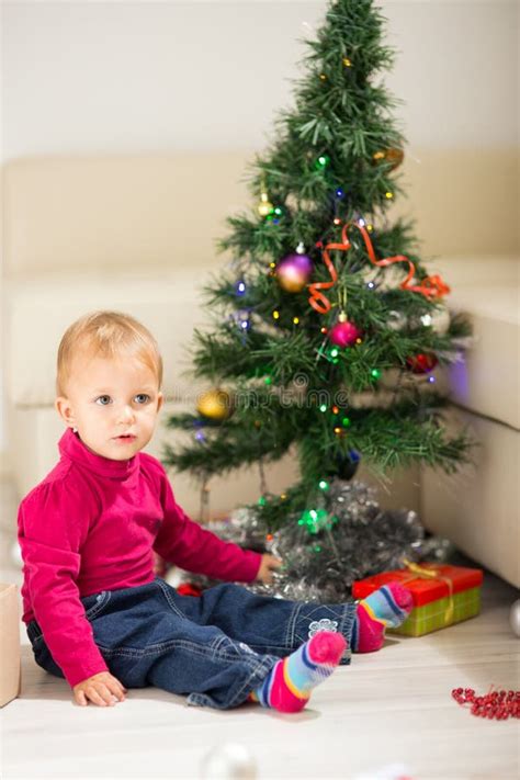 Baby near Christmas tree stock image. Image of hood, festive - 61388245