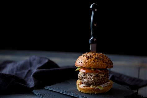 burger skewered with knife near black textile photo – Free Food Image ...