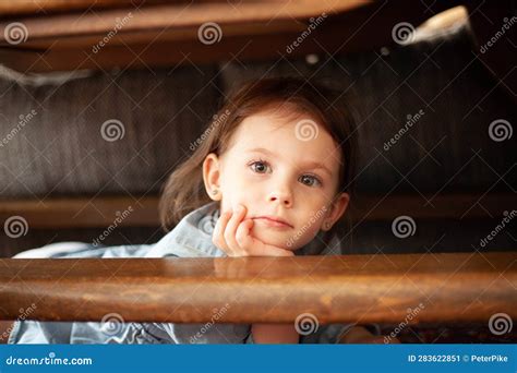 Portrait of a Cute Little Girl Sitting on the Stairs and Looking at the Camera Stock Image ...