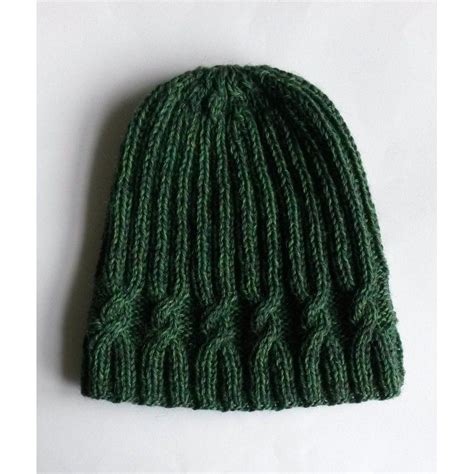 a green knitted hat laying on top of a white surface