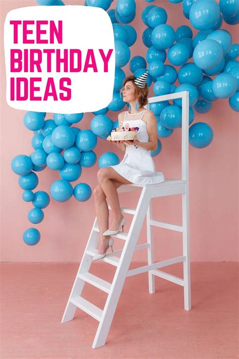 a woman sitting on top of a ladder holding a piece of cake in front of ...