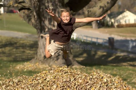 Girl Jumping into Leaf Pile Stock Image - Image of leaves, jumping: 11620879