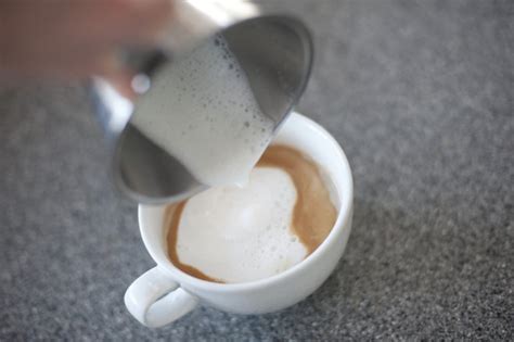 Adding steamed frothy milk to cappuccino - Free Stock Image