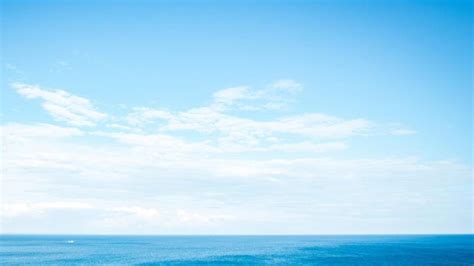 an ocean view with blue water and white clouds