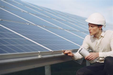 Serious young man working near solar panels · Free Stock Photo