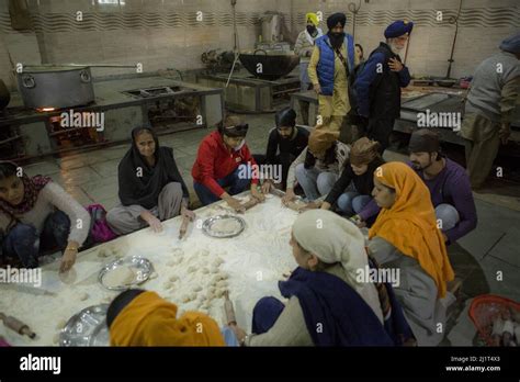 A view of tourists helping local women making traditional food with Sikh men cooking at the free ...