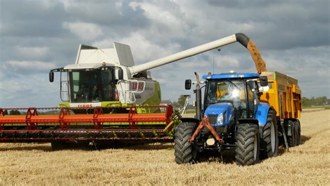 Blue Tractor Next to White Farm Vehicle at Daytime · Free Stock Photo