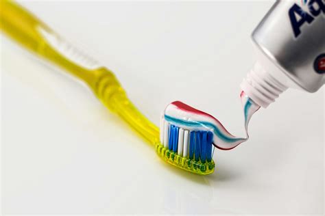 Toothpaste Being Put on Yellow Toothbrush · Free Stock Photo