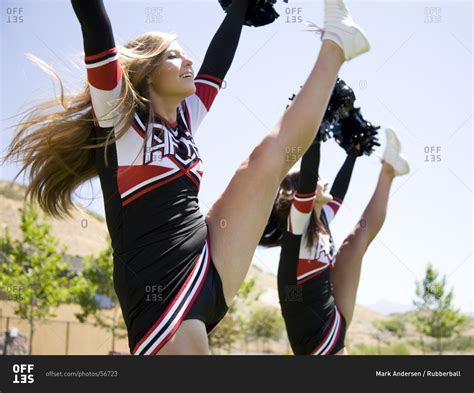 Cheerleaders doing high kick - Offset stock photo - OFFSET