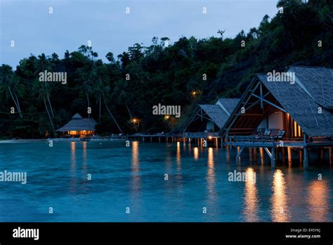 Bungalows of Misool Eco Resort as night falls. Misool, Raja Ampat, West ...